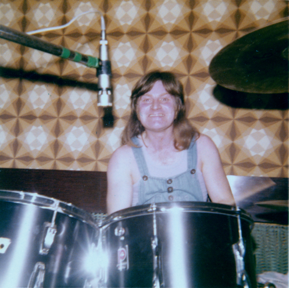 Cycle's drummer, Norman Smith, sitting behind his double drumkit and smiling for the camera