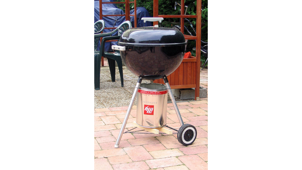 A Weber barbecue fitted with a huge Illy coffee can as an ash collector.